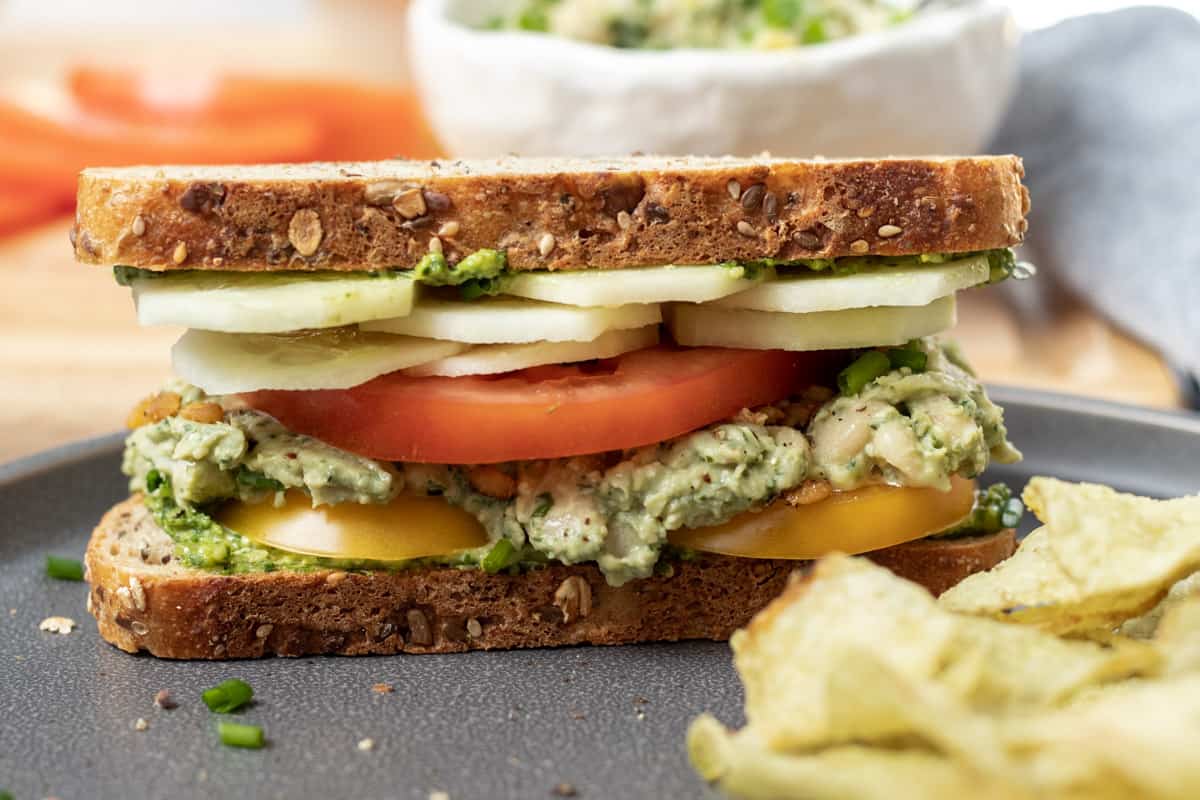 a sandwich made with pesto-white bean spread plus cucumber and tomato.
