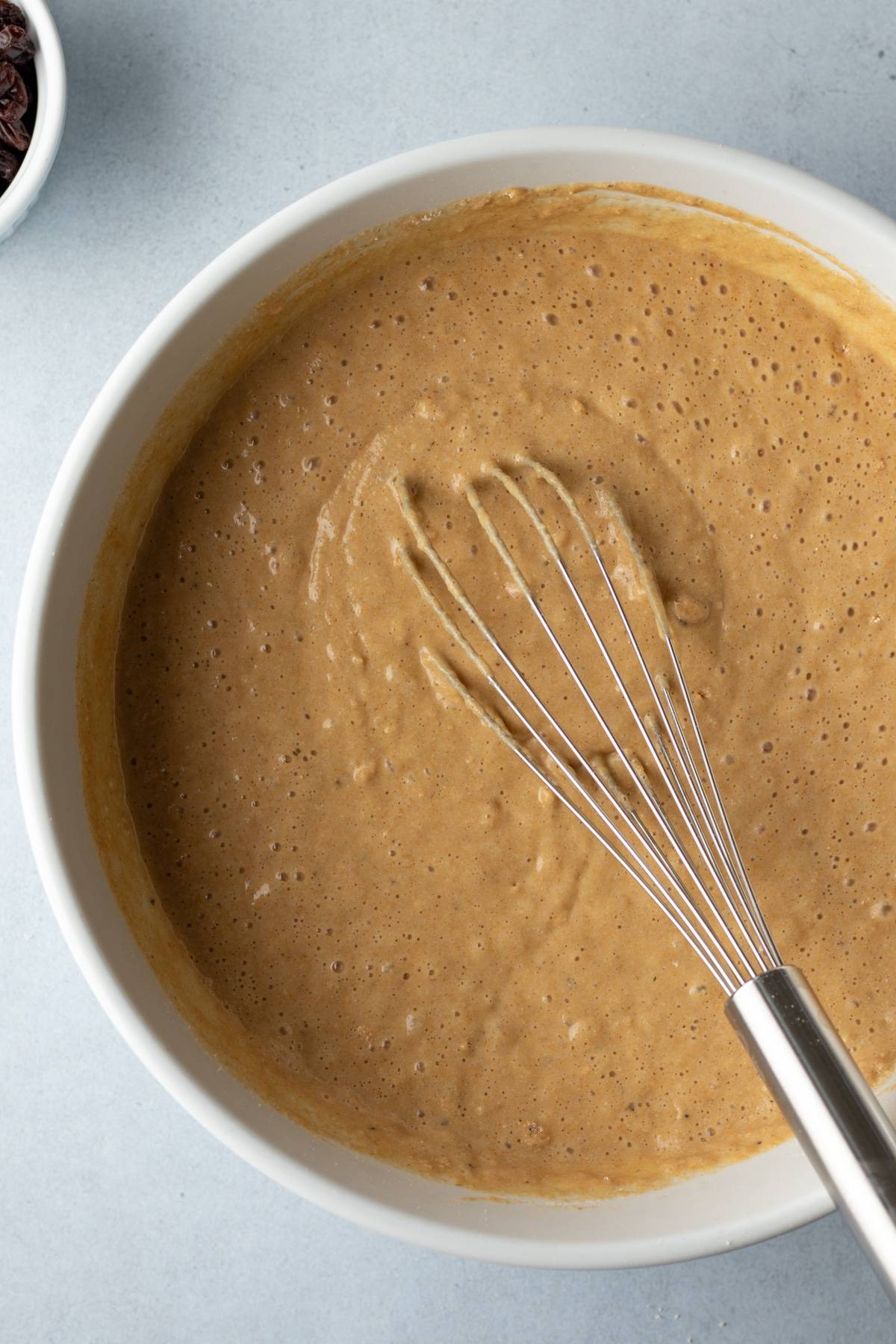 whisking muffin batter in a mixing bowl.