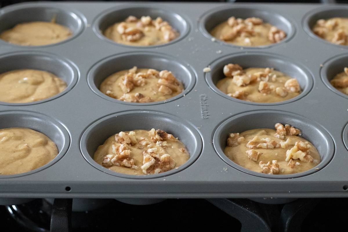 filling muffin pan with batter.