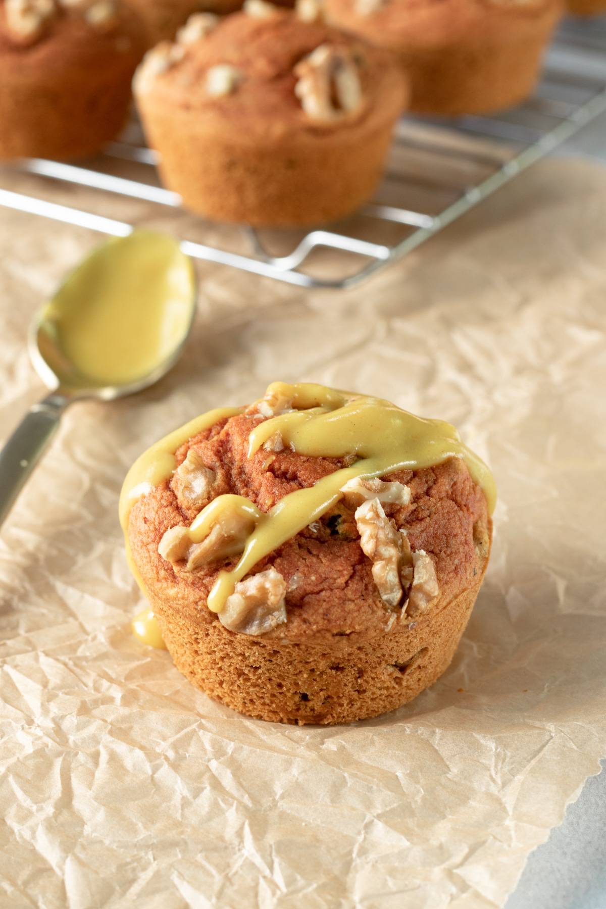 turmeric muffin on parchment paper with other muffins on a cooling rack.