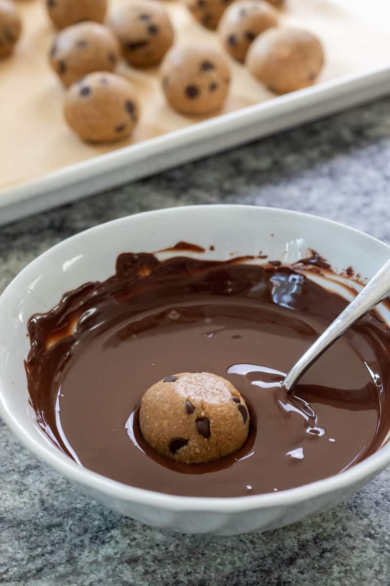 dunking cookie dough balls in melted chocolate