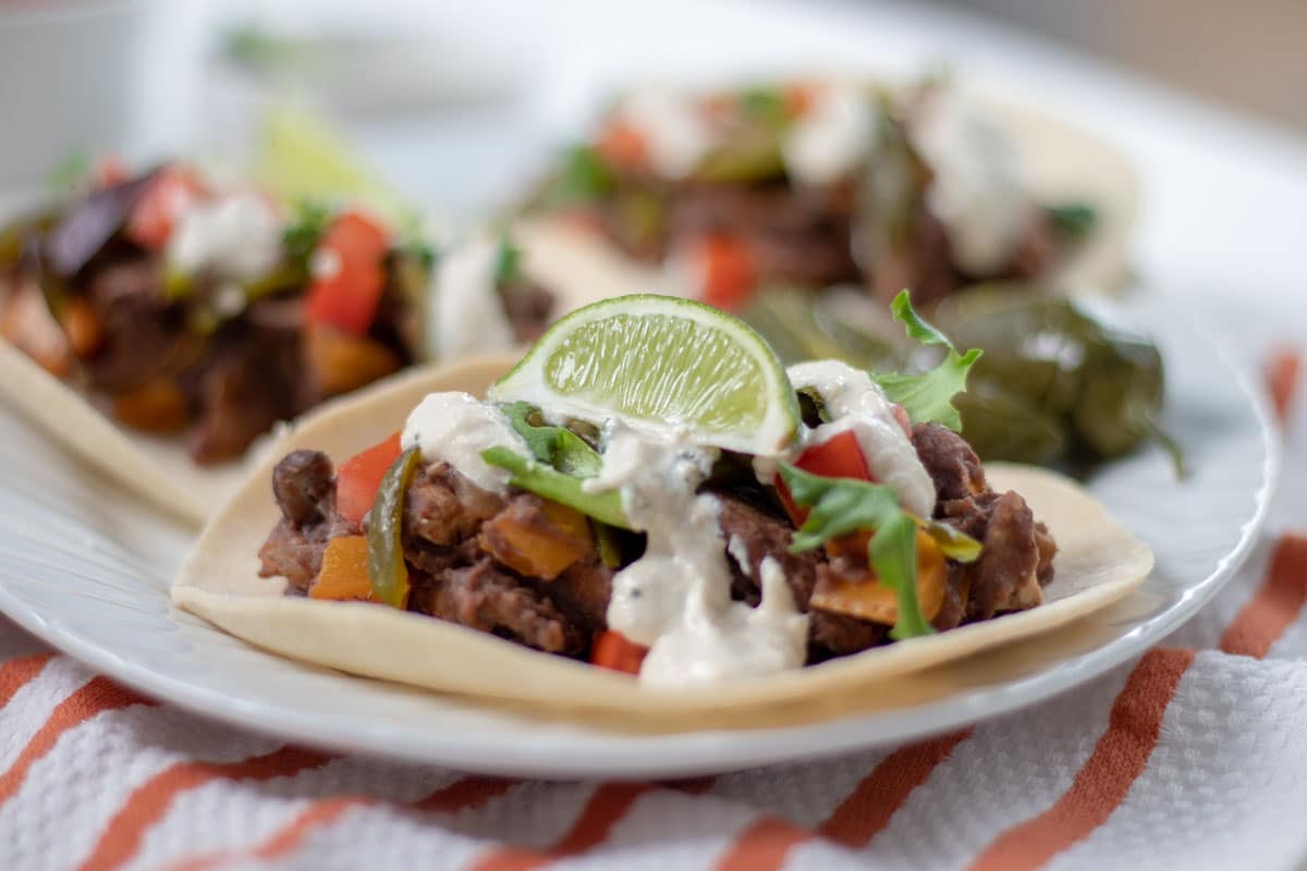 close up of tacos topped with Creamy Lime Dressing and a lime wedge