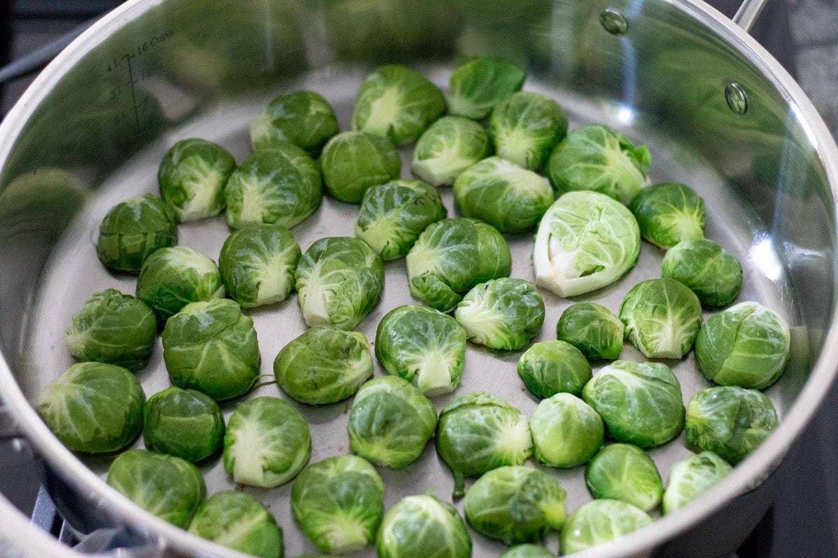 searing halved Brussels sprouts cut-side down in a pan.