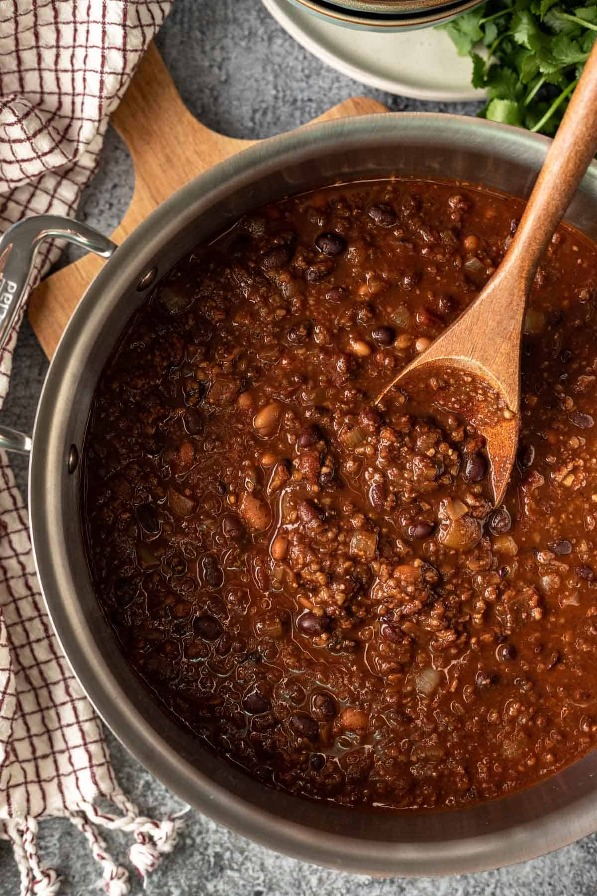 Close up of chili in a stainless pot showing the texture of bulgur, beans, and ground walnuts.