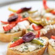 Vegan Crostini with herbed almond ricotta on a white plate