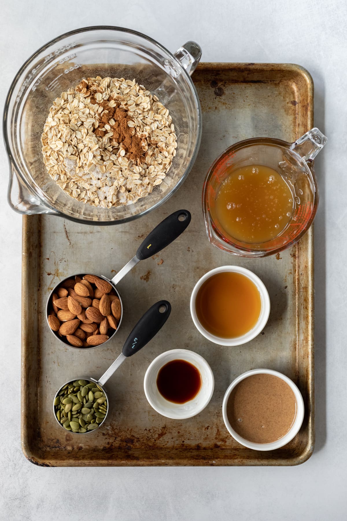 granola ingredients laid out on a large sheet pan.