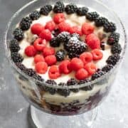 trifle in a large glass trifle dish topped with berries