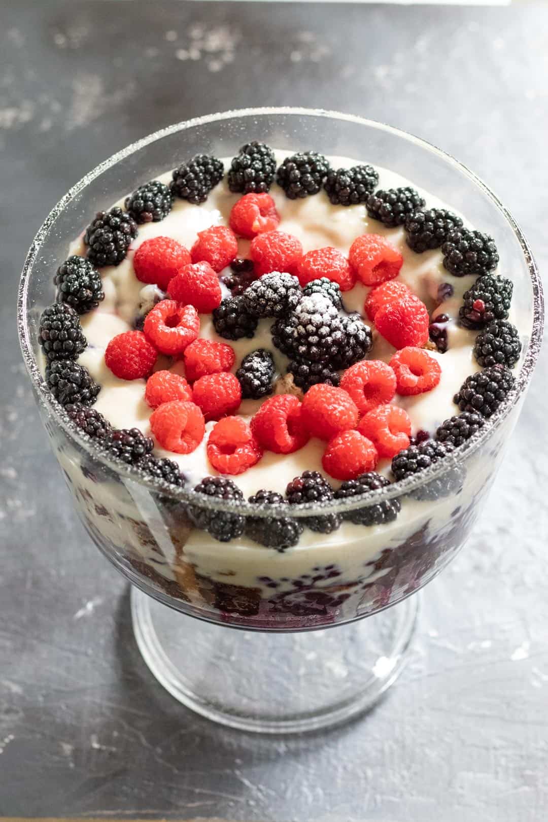trifle in a large glass trifle dish topped with berries
