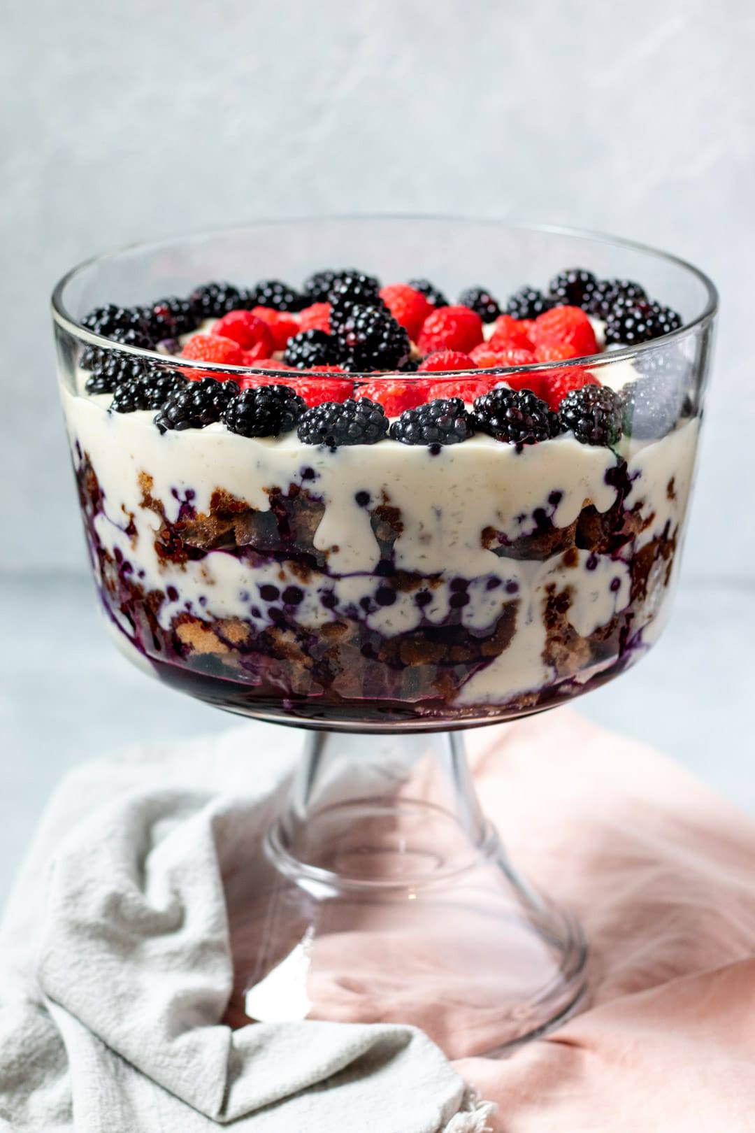 Vegan Trifle in a large glass trifle dish showing layers of pudding and berries