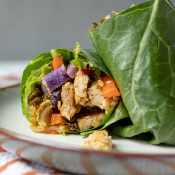 close up of a cut collard wrap showing tempeh and vegetables inside.