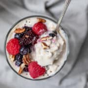 overhead view of yogurt overnight oats in a glass with berries and nuts.