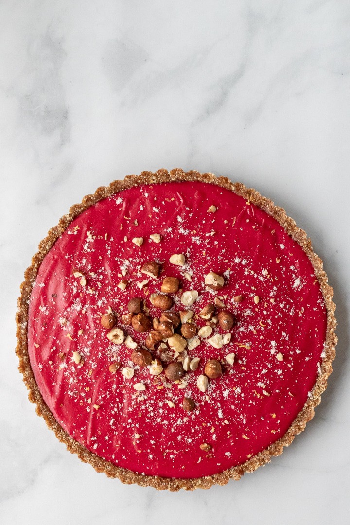 whole tart decorated with hazelnuts and coconut flour