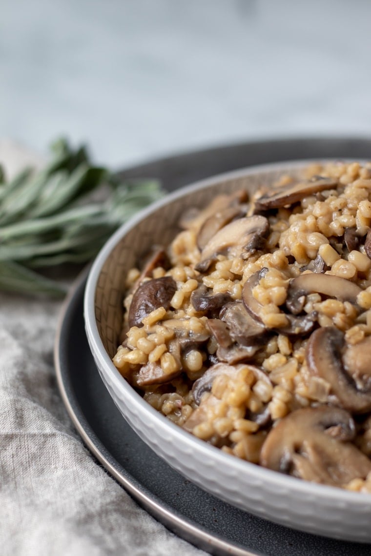 Creamy mushroom barley orzotto in a gray serving bowl.