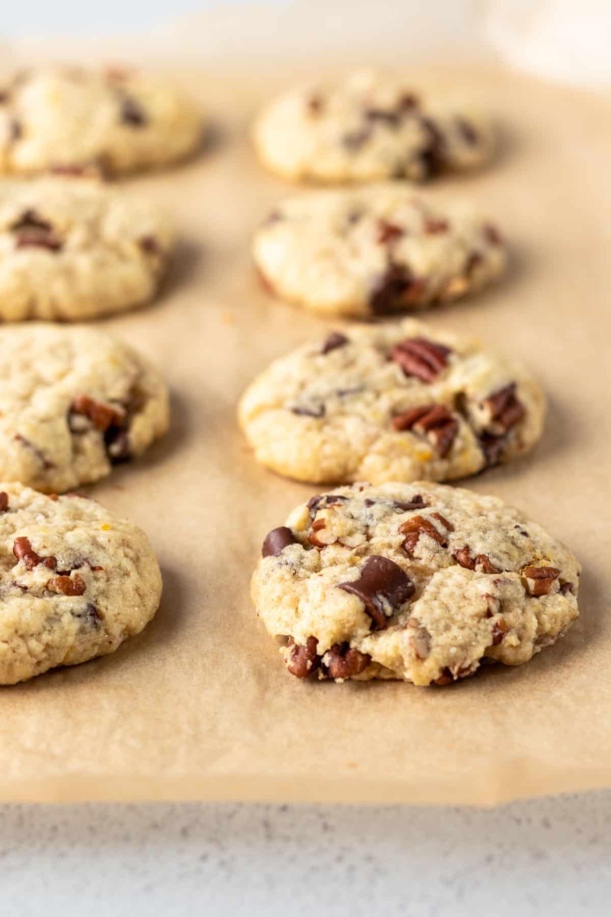 Chunky pecan cookies cooling on parchment paper.