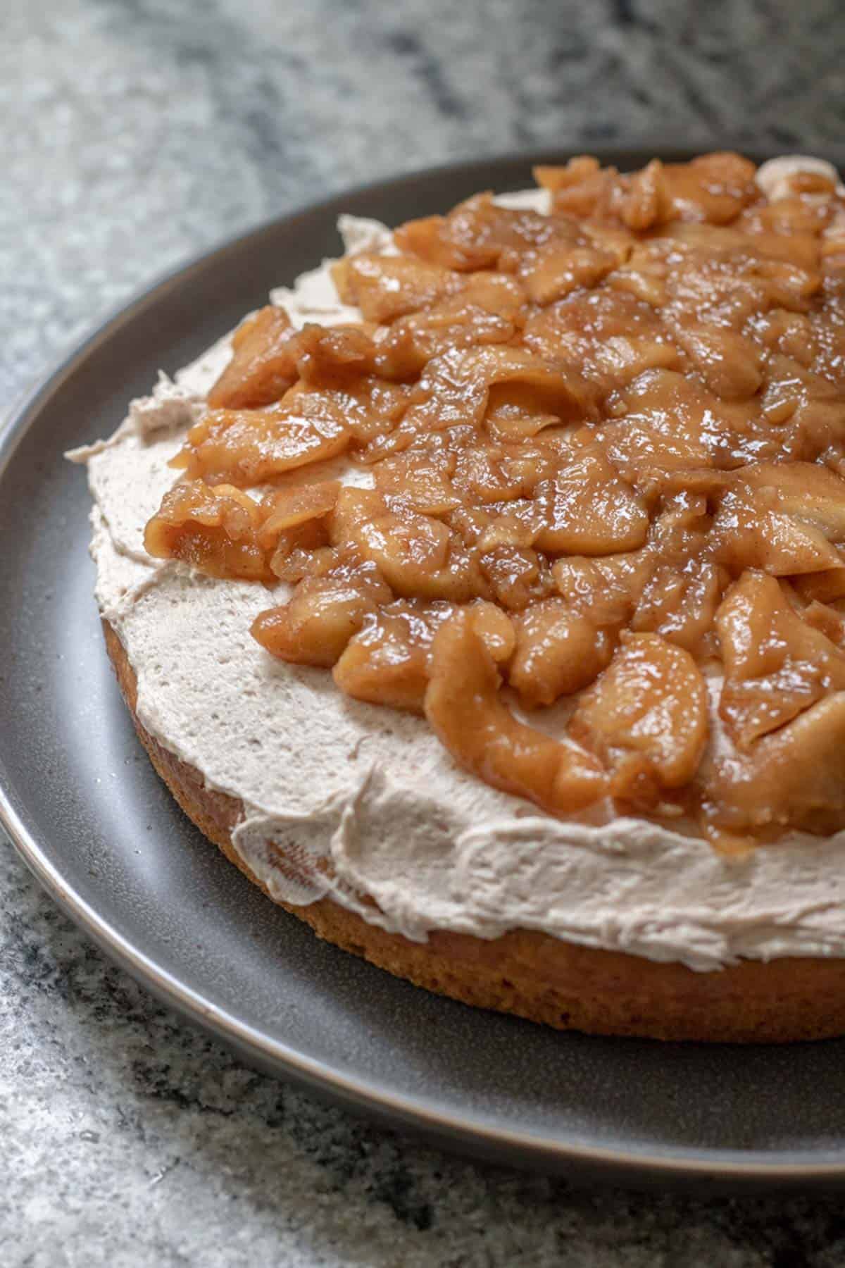 first layer of cake, frosted and topped with bourbon-apple filling