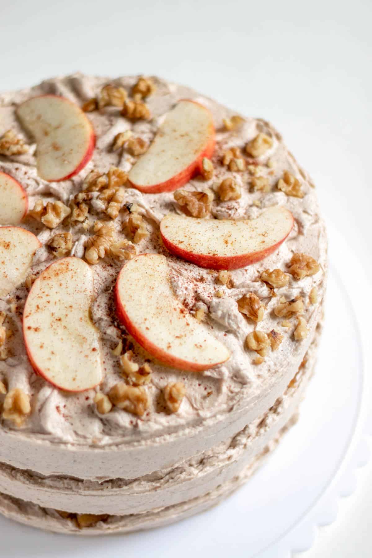 a view of the top of the decorated cake with apple slices and walnuts.