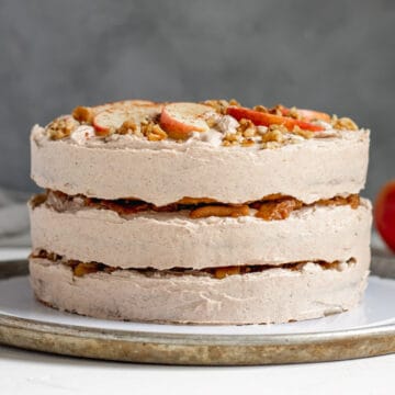 side view of the decorated apple cake with apples peeking through between the layers.