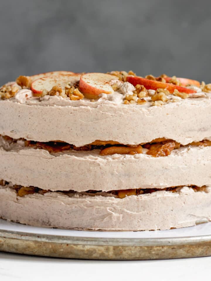 side view of the decorated apple cake with apples peeking through between the layers.