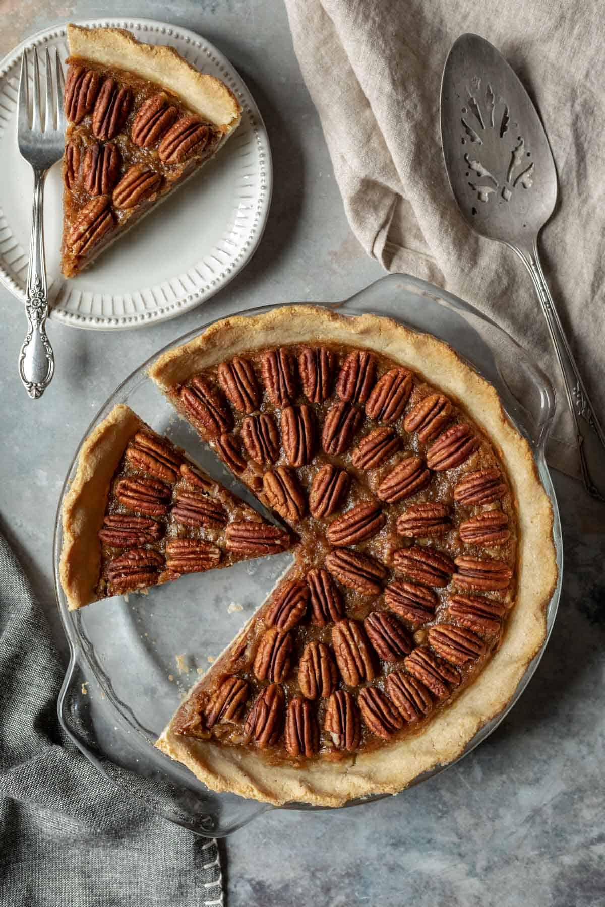 circles of pecans decorating the top of vegan bourbon pecan pie with a slice removed.