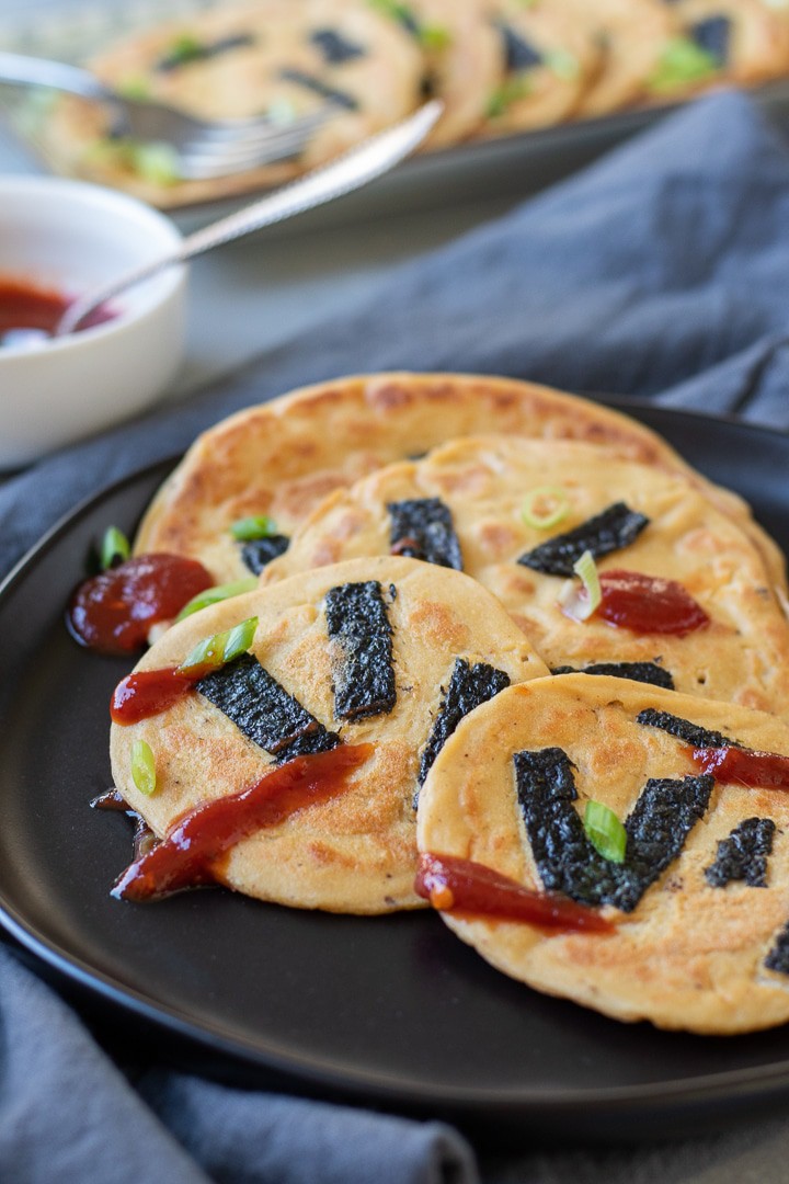 Tofu pancakes on a black plate.