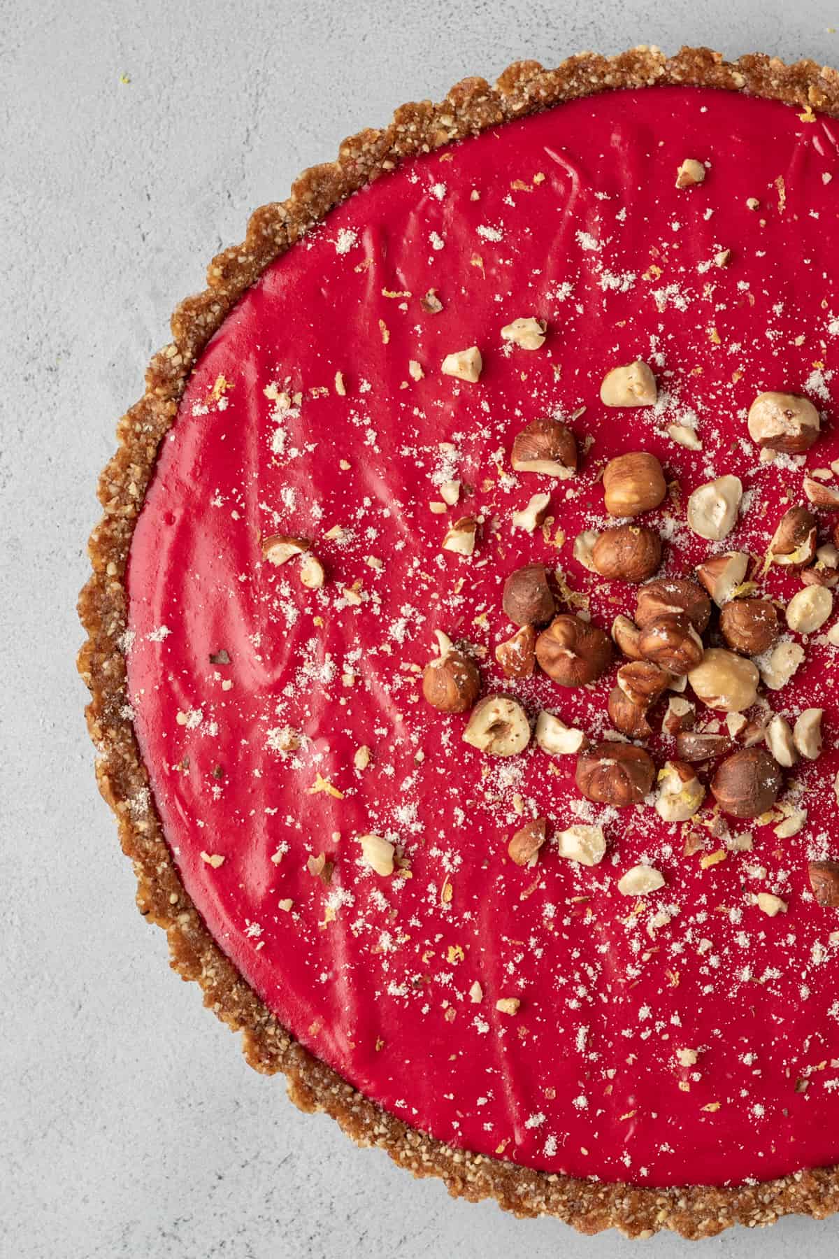 bright red tart topped with hazelnuts