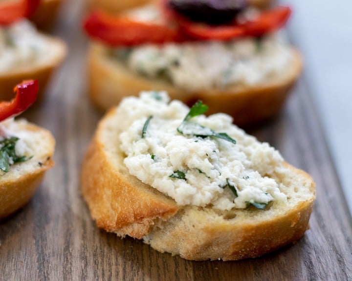 Almond ricotta mixed with fresh herbs spread on toasted baguette