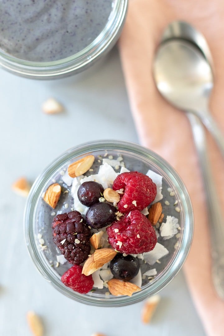 overhead shot of Berries and Greens Breakfast Pudding topped with coconut, berries and almonds