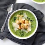 overhead view of cream of kale soup topped with croutons.