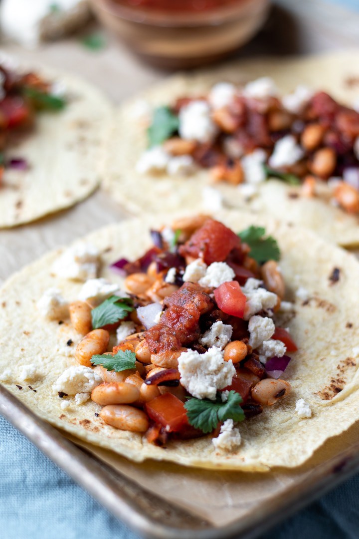 Smoky White Bean Tacos topped with salsa, cilantro and Almond Queso Blanco