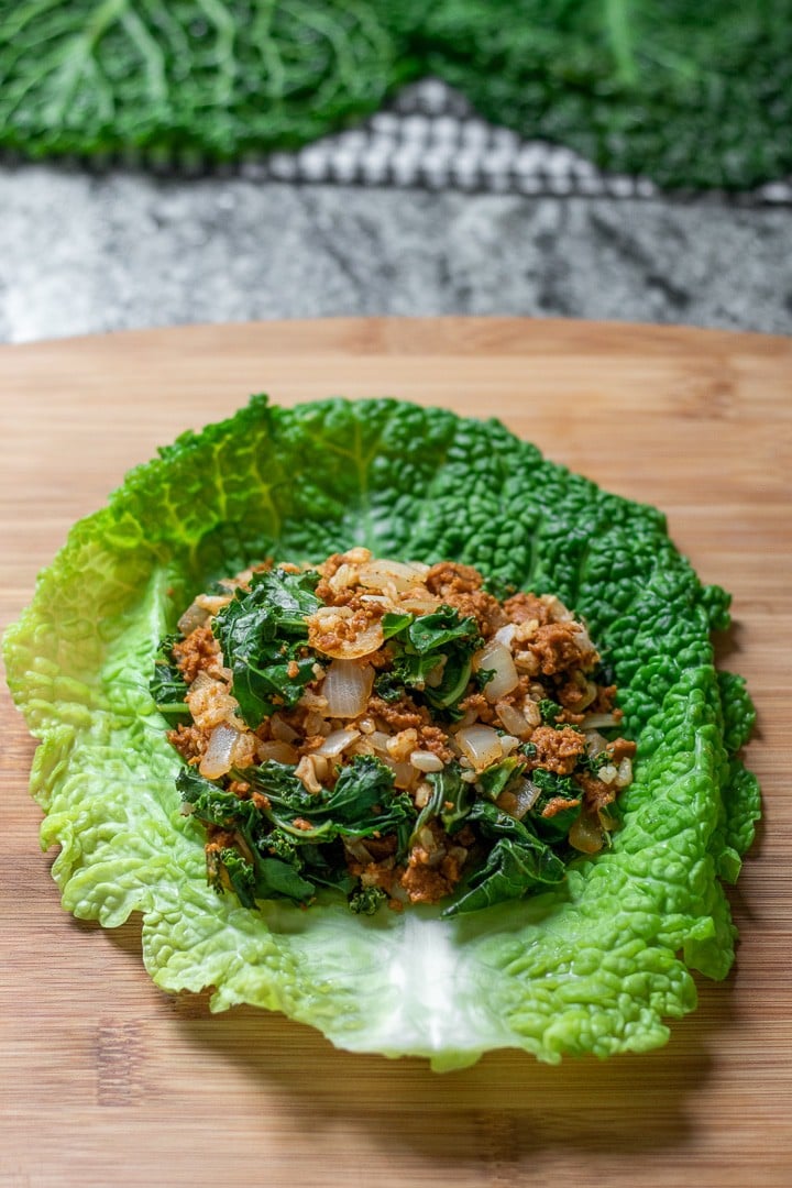 chorizo stuffing on a cabbage leaf ready to be rolled.