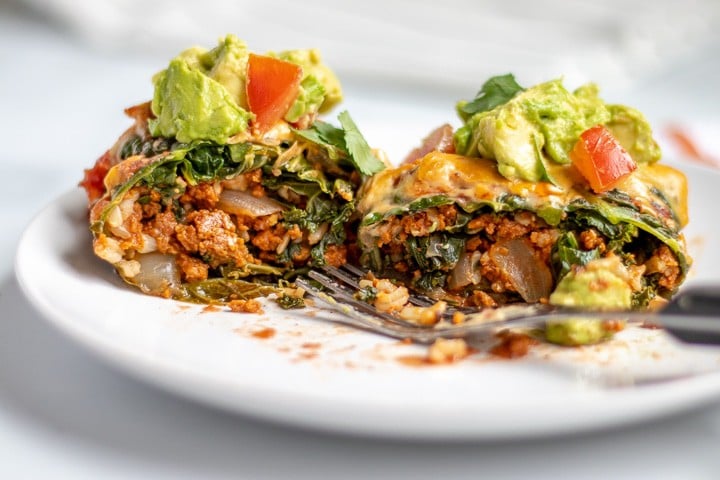 A cabbage roll cut in half to show the filling inside.