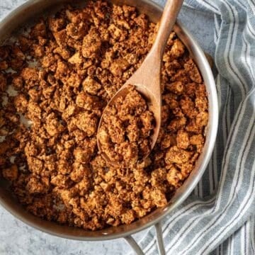 Spicy tofu chorizo being scooped up from a saute pan.