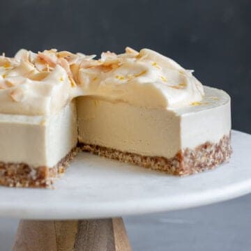 close up showing inside texture of cheesecake topped with aquafaba and toasted coconut.