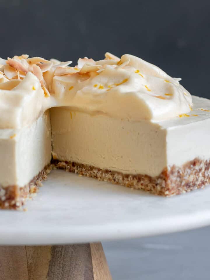 close up showing inside texture of cheesecake topped with aquafaba and toasted coconut.
