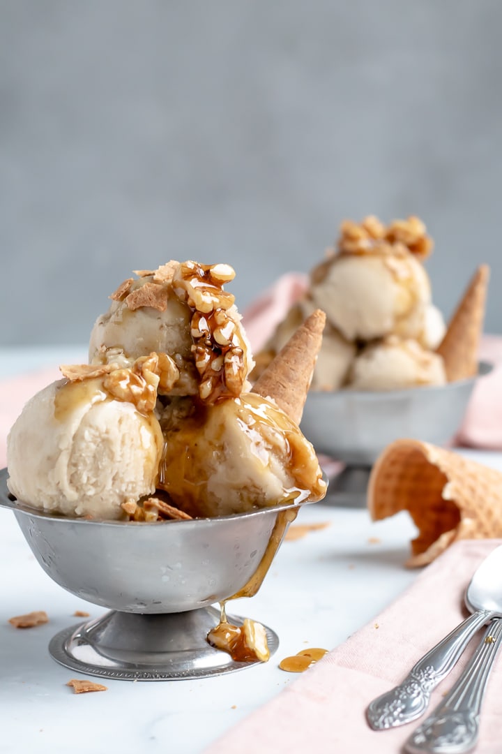 banana nice cream with wet walnuts in two silver serving bowls