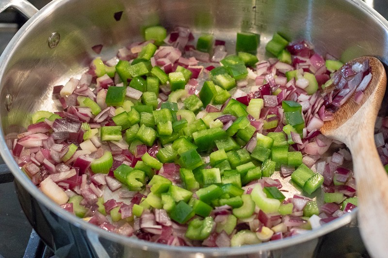 onion, celery and bell pepper cooking in a pan.