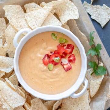 Easy Oil-Free Vegan Queso on a platter surrounded by tortilla chips