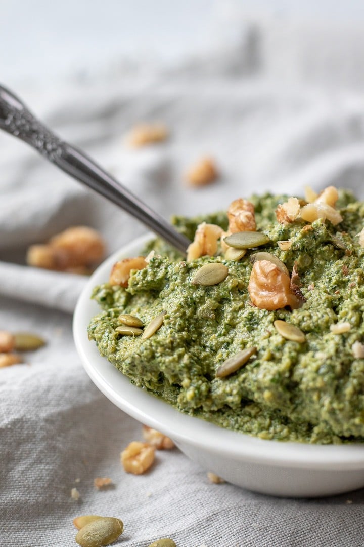 Thick and green dill pesto in a white bowl.