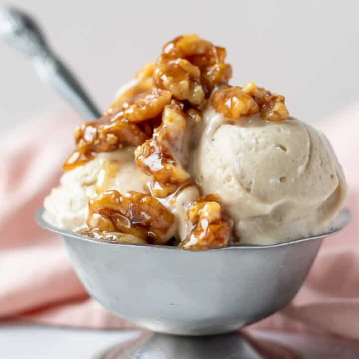 Scoops of nice cream topped with wet walnuts in a small serving dish.