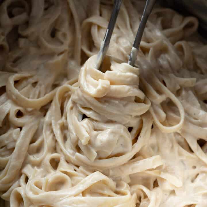 close up of creamy vegan alfredo in a pasta pot.
