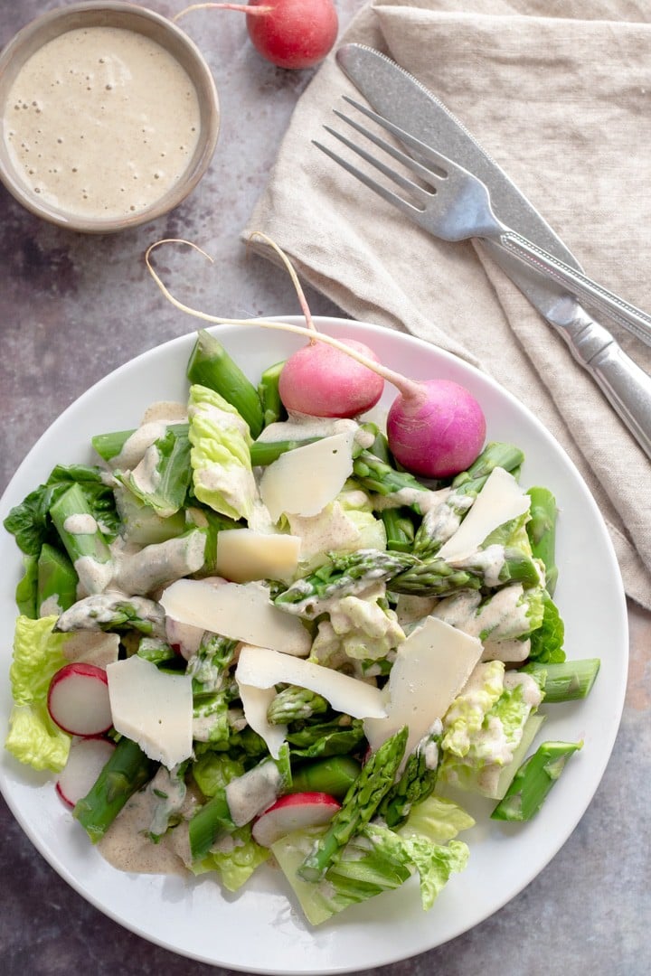 overhead shot of asparagus salad on a white plate.