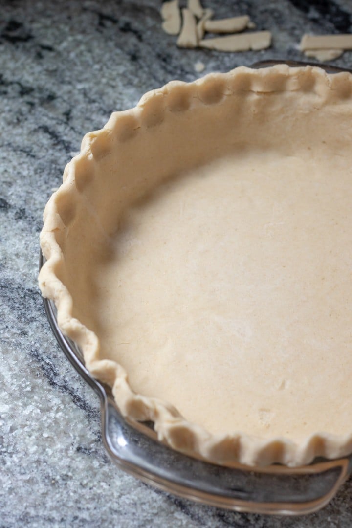 unbaked pie crust in a glass pie plate for haupia pie.