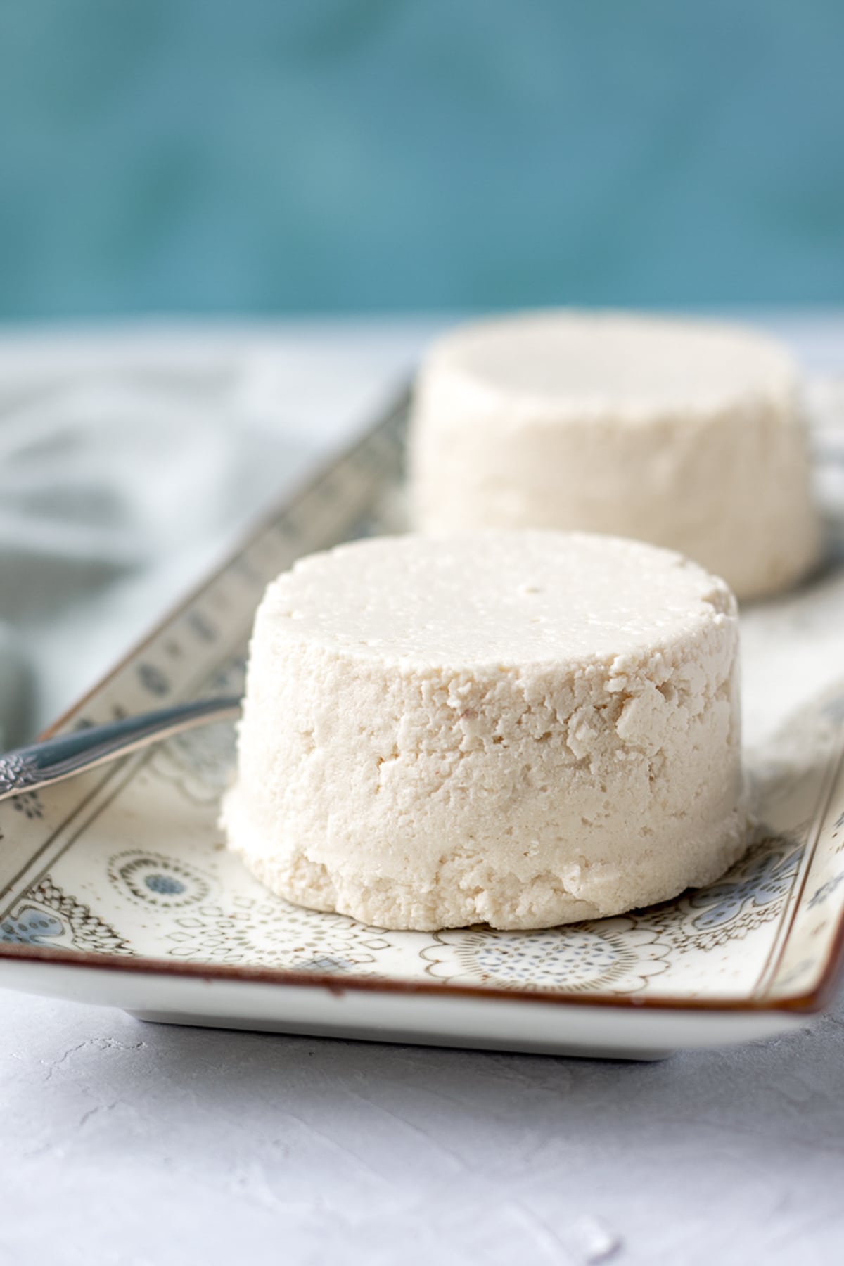 two rounds of vegan queso fresco on a platter.