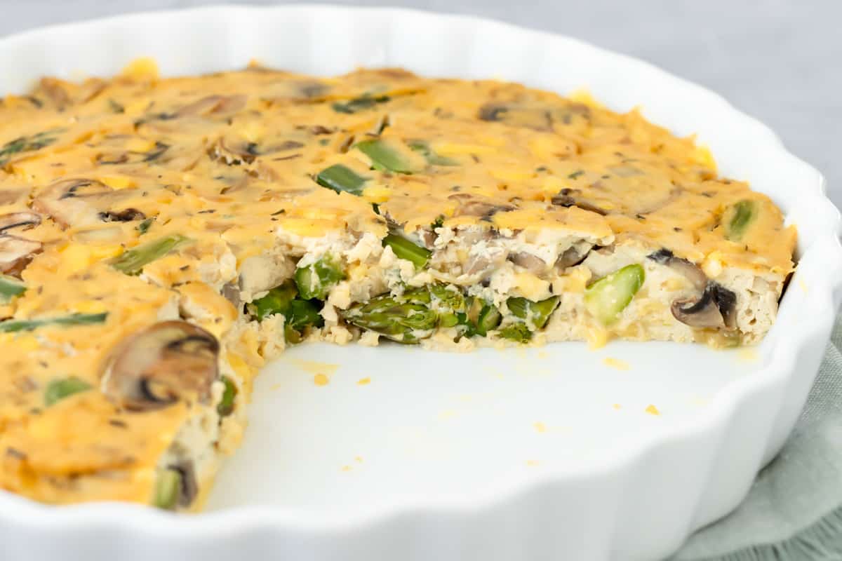side view of quiche showing asparagus and mushrooms inside the tofu filling.