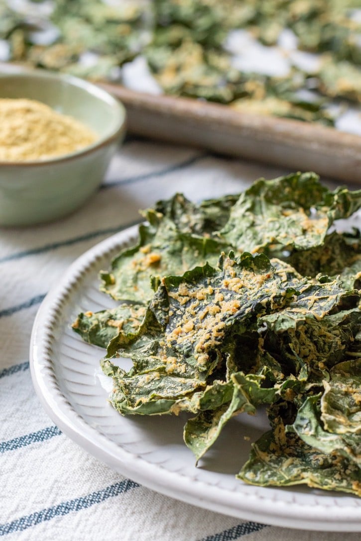 oil-free kale chips stacked on a plate.