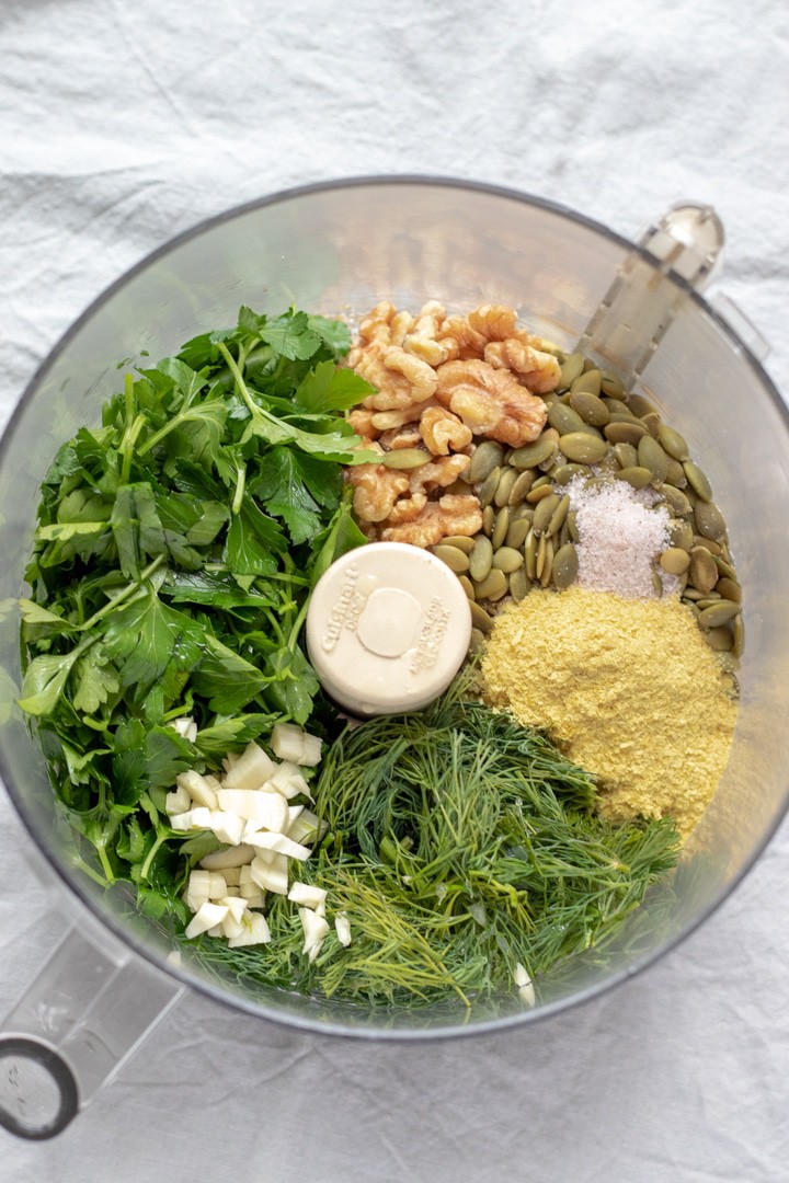 pesto ingredients in bowl of food processor.