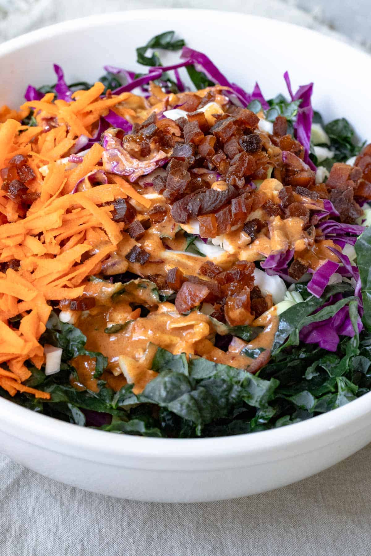 preparing kale slaw in a large bowl.