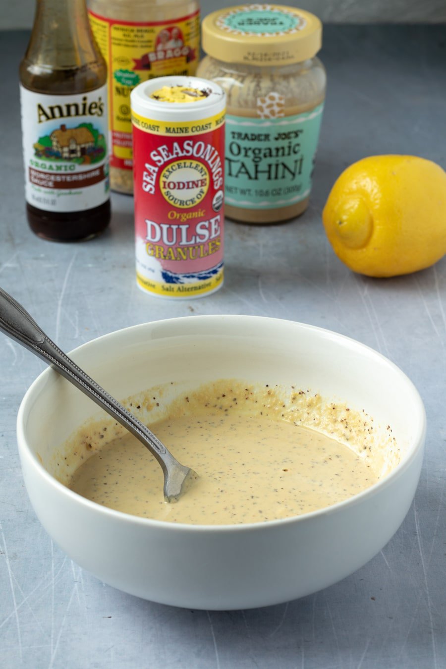 stirring the Caesar dressing together in a bowl.