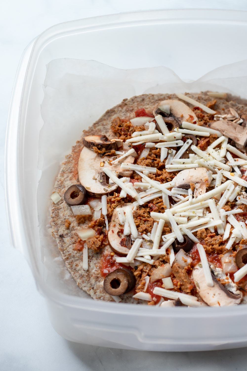 pizzas in a large storage container ready to be frozen