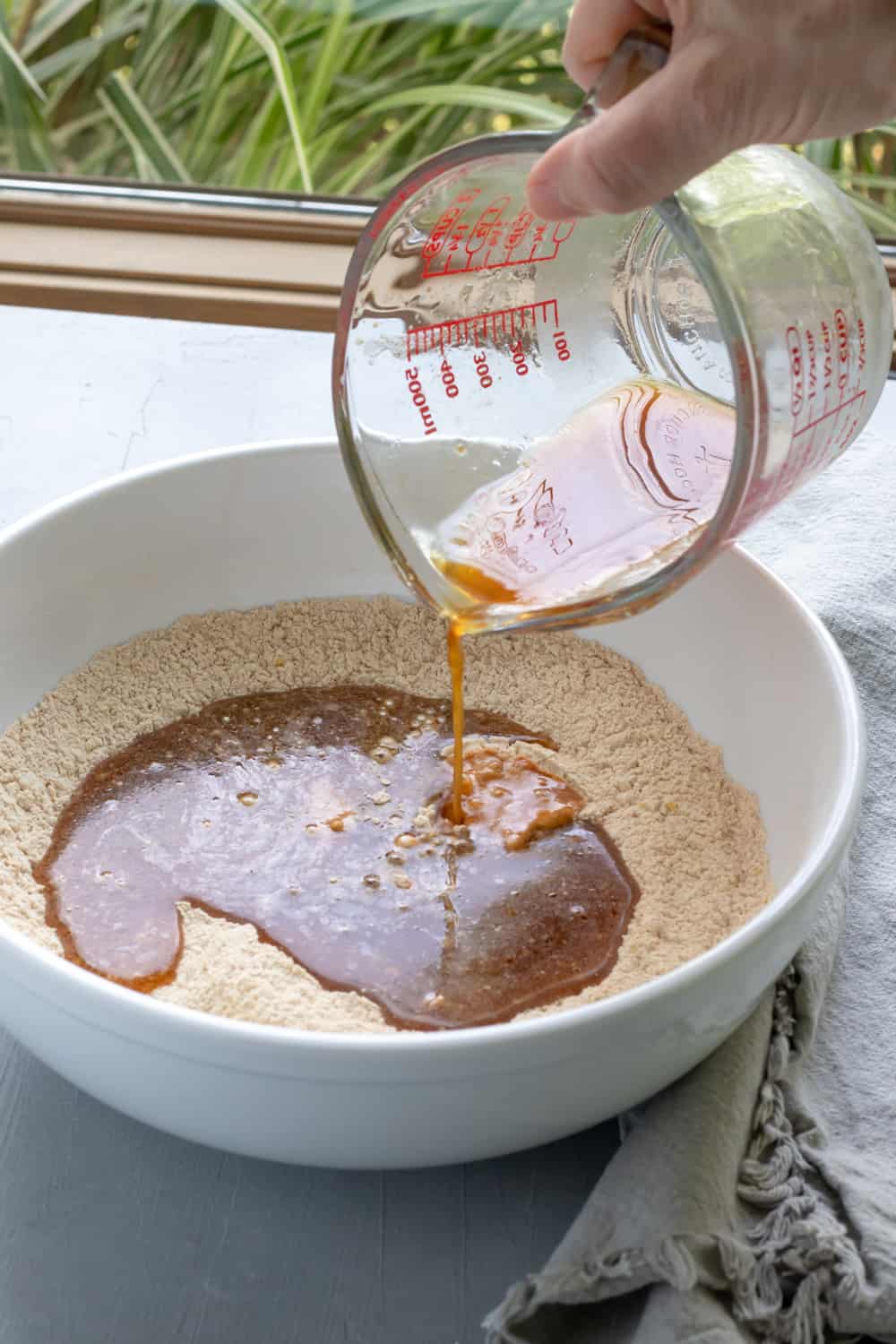 preparing seitan dough, pouring wet ingredients into dry.